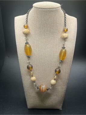 Glass bead necklace by Avenue featuring amber, cream, and banded art glass